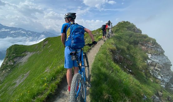 grupo de ciclistas practicando mountainbike por la montaña con tuntuntrip